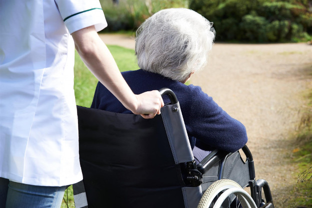 Healthcare worker assisting patient in wheelchair