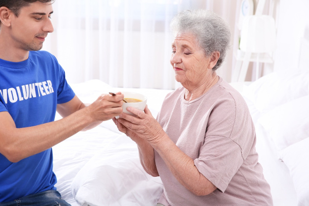 volunteer feeding the elderly