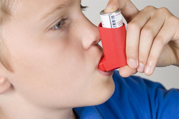 child using asthma inhaler